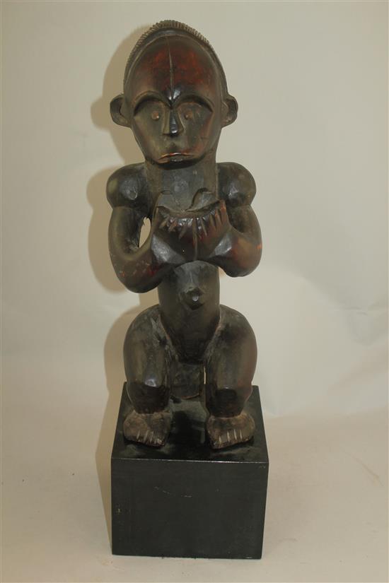 A West African carved hardwood figure of a seated male, overall 22in.